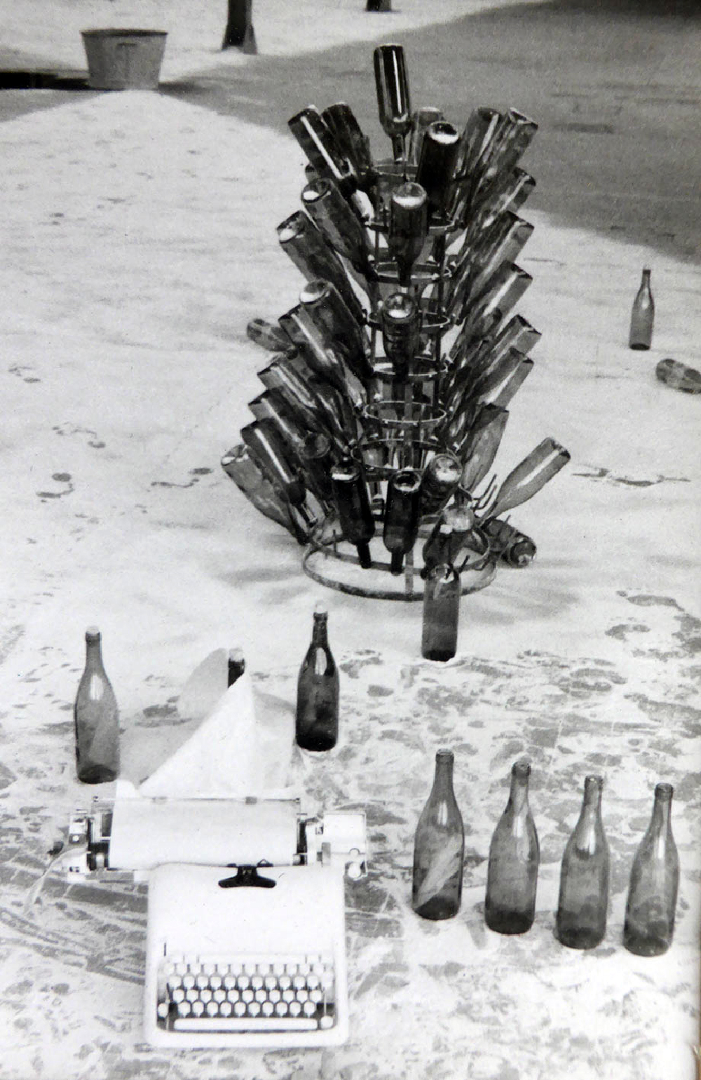 Langue Cassée, 1994, eleven hour poem, construction in process, bottle rack, wine bottles, whited out typewriter (Phil Coy  0)